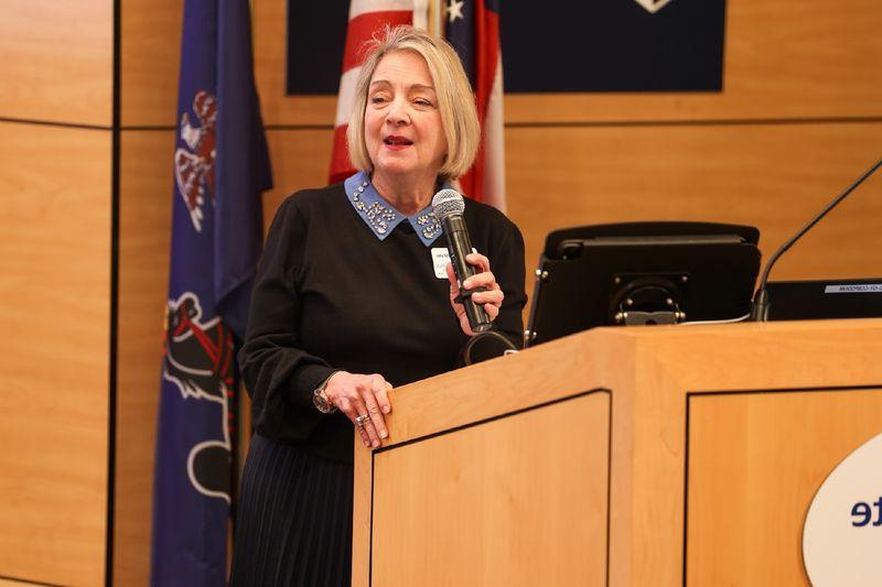 Regional Chancellor Marilyn J. Wells holding microphone