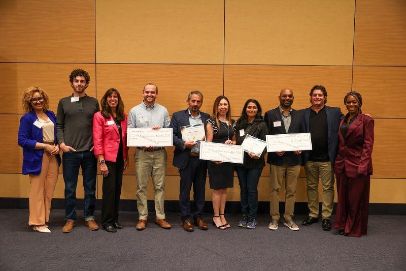 contestants holding large checks